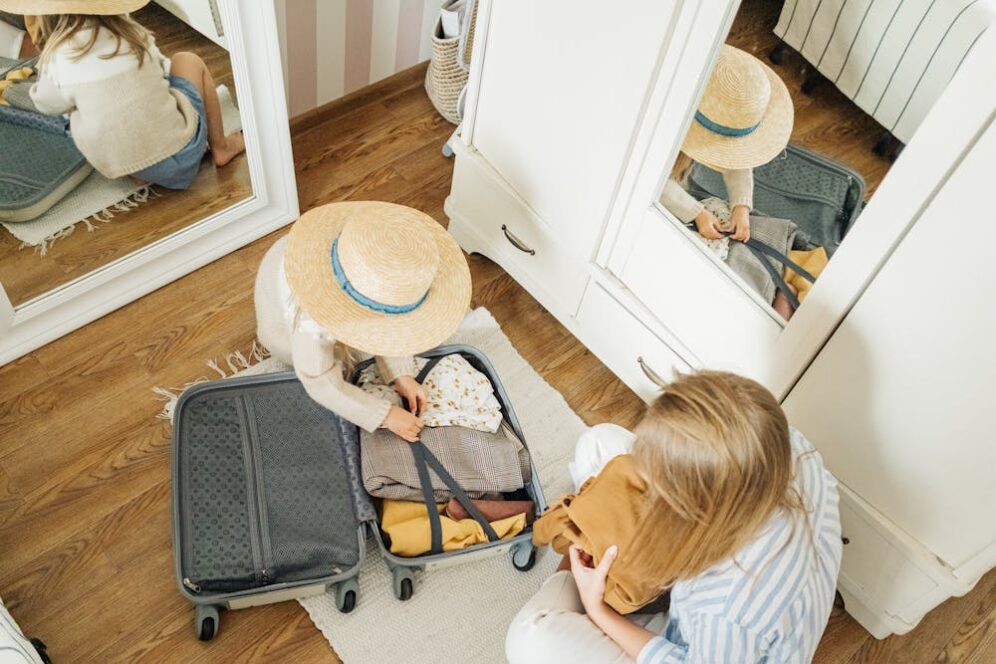 Two women packing a suitcase.